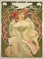 A bare shouldered red-haired woman in an embroidered white gown turns the pages of a large format book containing decorative designs. She is framed by a halo decorated with pinkflowers.