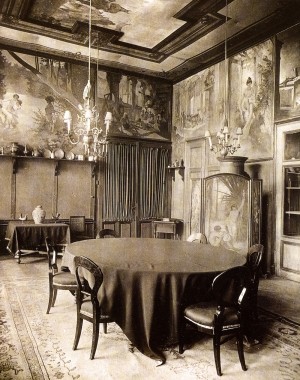 Interior view of Mucha's mural decorations at Emmahof castle Dining room with dining table and chairs and scenes painted by Mucha on the walls and ceiling behind