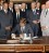 President Kennedy signs the Limited Nuclear Test Ban Treaty Kennedy sits at a desk surrounded by men in suits