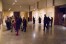 Visitors look at lithographs by Mucha in a large rectangular room
